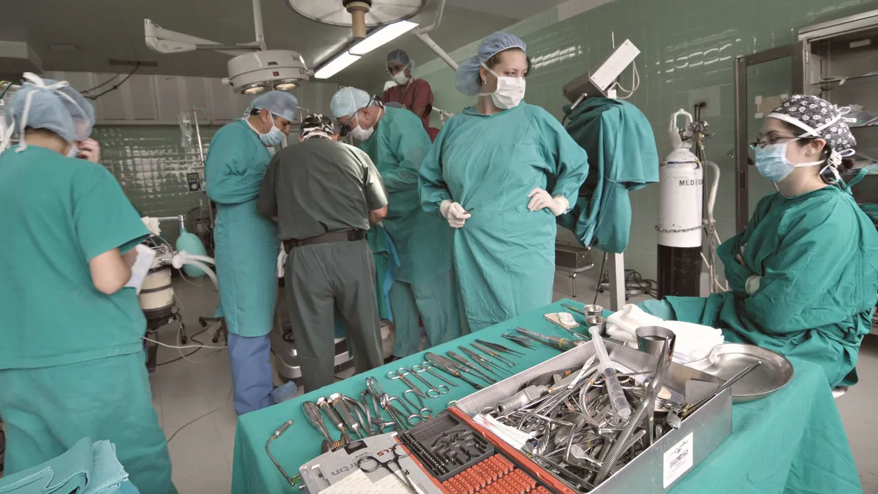 Surgeons wearing masks and scrubs collaborate during a medical operation in an operating room.