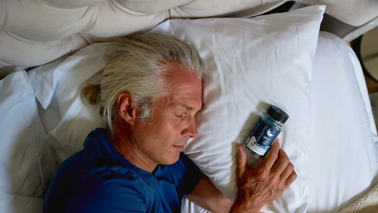 a man laying in bed holding a cell phone