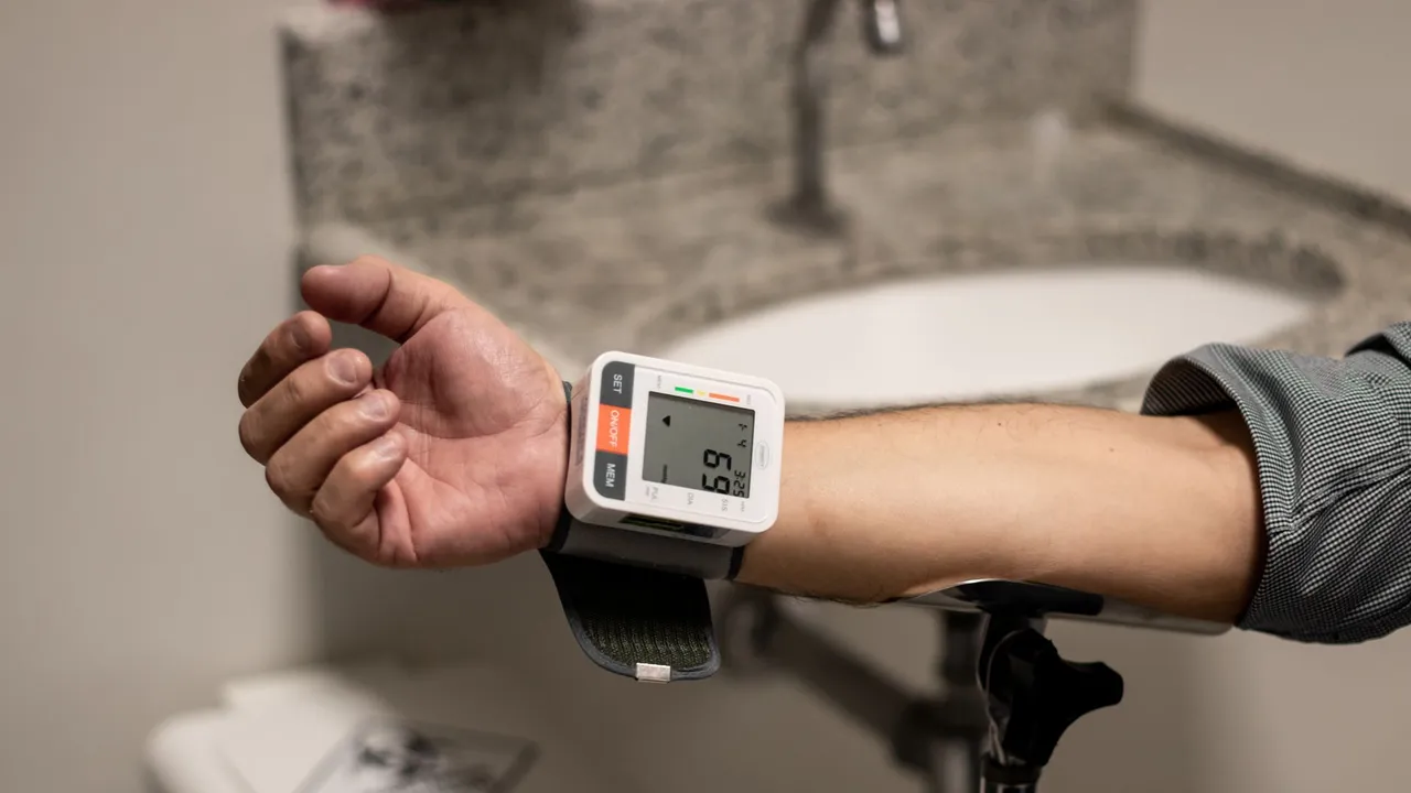 Close-up of an arm using a wrist sphygmomanometer in a healthcare setting.